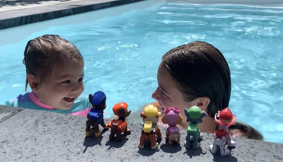 2 jeunes enfants jouent au bord de la piscine avec des jouets