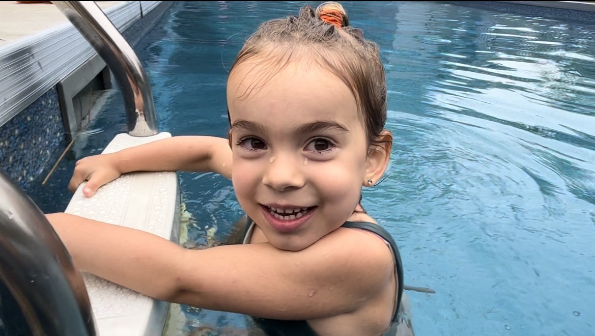 Une jeune nageuse grimpe les marchent d'une piscine creusée