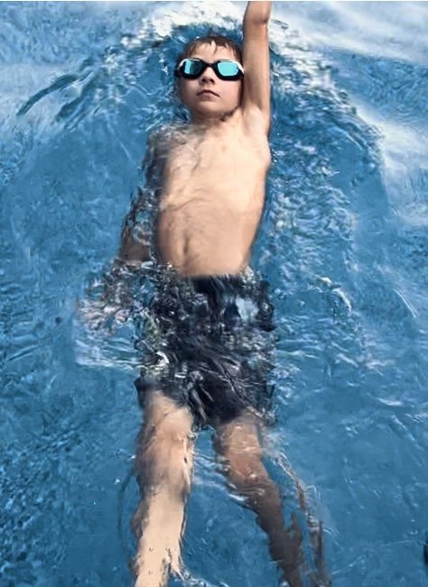 Un jeune élève de chez AquaStars nage sur le dos