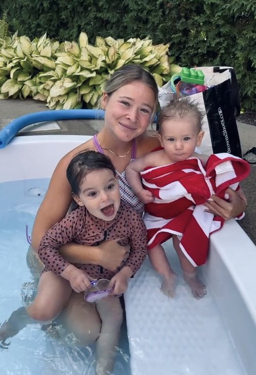 Une monitrice aquatique pose avec ses élèves lors d'un cours de natation à domicile